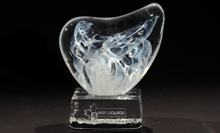 The trophy has a cast base and a body made of hot sculpted glass by the artist